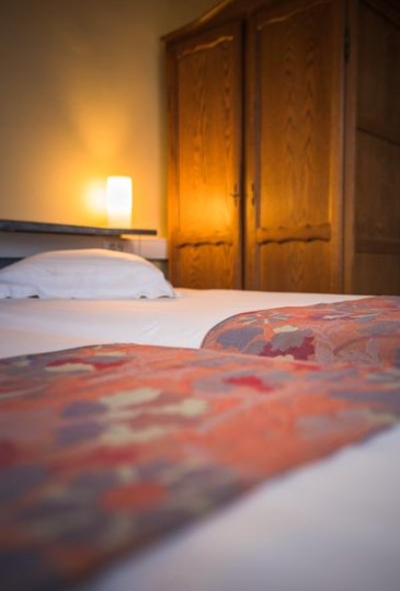 Two beds of the 2 person family room in a rustic setting