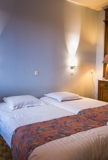 zicht op twee persoonskamer met twee gescheiden bedden