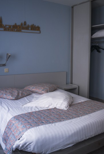 zicht op het groot bed van de king size room met extra kus in de kast.